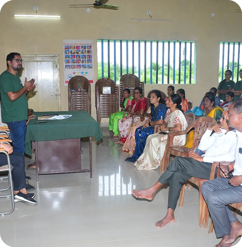 A presenter speaking with farmers at a community meeting